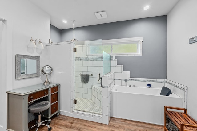 bathroom with recessed lighting, wood finished floors, a shower stall, and a bath
