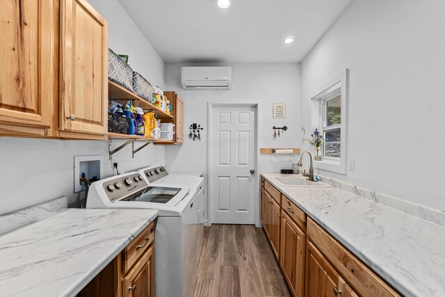 laundry room with independent washer and dryer, cabinet space, dark wood-style flooring, a wall mounted AC, and a sink