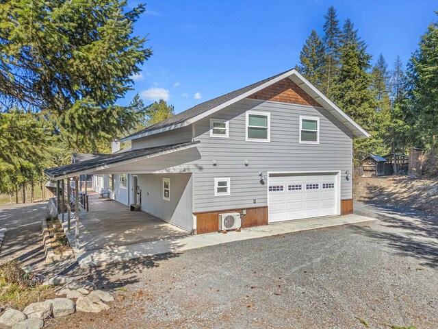 exterior space with a carport, dirt driveway, and ac unit