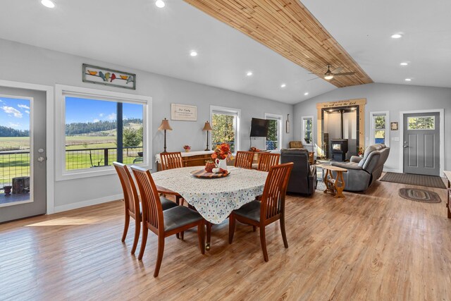 dining room with light wood-style flooring, ceiling fan, a wealth of natural light, and lofted ceiling