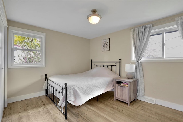 bedroom with baseboards and light wood-type flooring