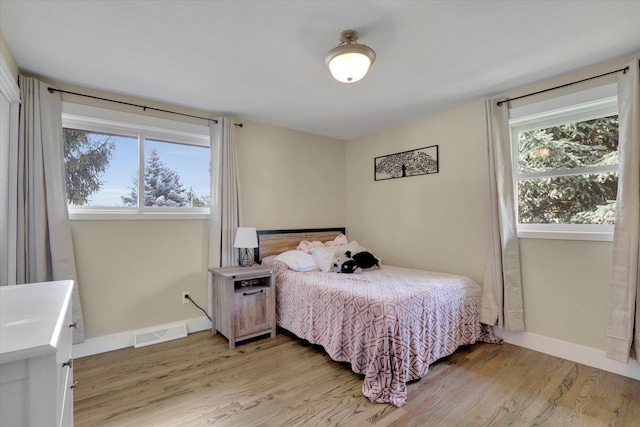 bedroom with visible vents, baseboards, and light wood-style floors
