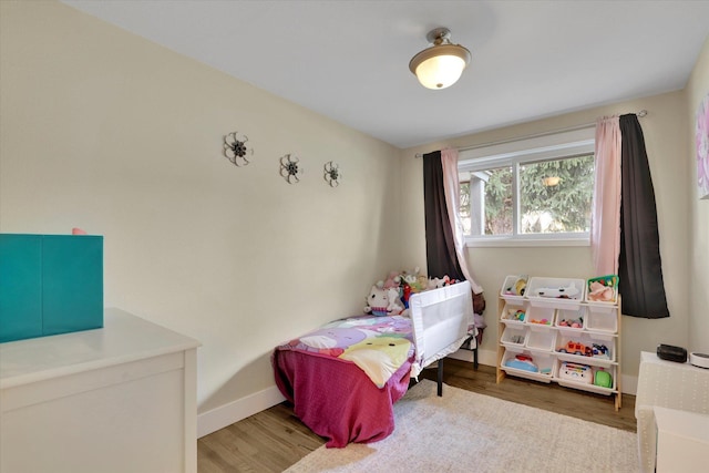 bedroom with baseboards and wood finished floors