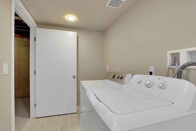 washroom with visible vents, washer and clothes dryer, and laundry area