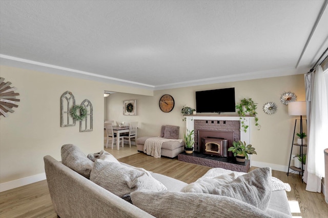 living area with a fireplace, light wood-style flooring, and baseboards