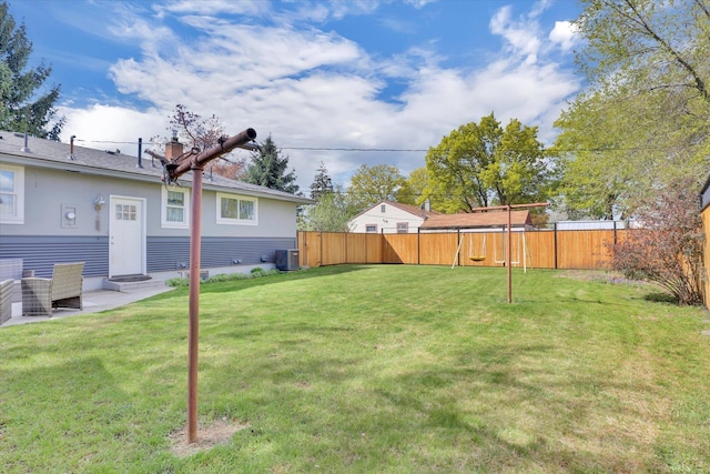 view of yard featuring a fenced backyard, central AC unit, and entry steps