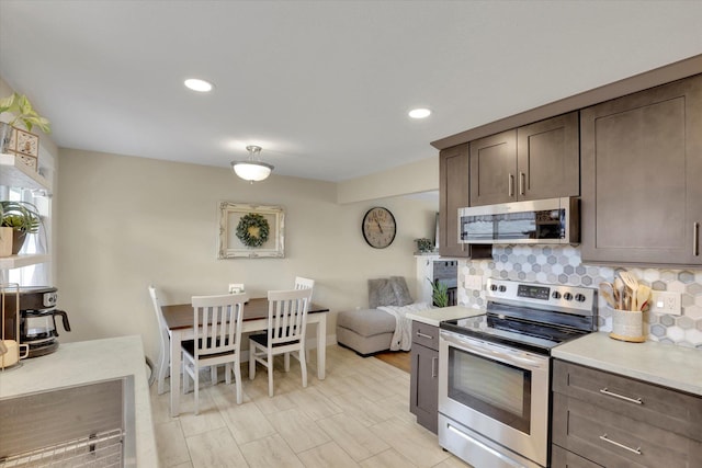 kitchen with tasteful backsplash, dark brown cabinets, appliances with stainless steel finishes, and recessed lighting