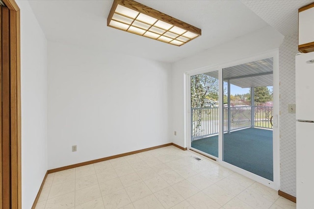 unfurnished room with visible vents and baseboards