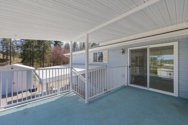 view of patio / terrace featuring an outdoor structure, a shed, and a balcony