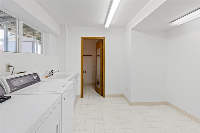 laundry area featuring washer and dryer, baseboards, laundry area, and a sink