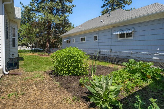 817 W Frederick Ave, Spokane, WA 99205 - view of home's exterior with fence, roof with shingles, and a lawn