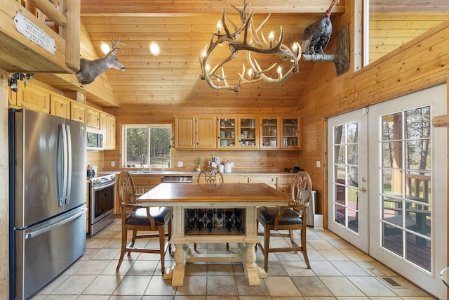 kitchen with a sink, appliances with stainless steel finishes, wooden ceiling, an inviting chandelier, and french doors