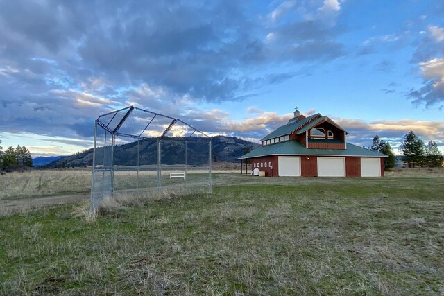 view of yard featuring an outdoor structure, a rural view, and a garage