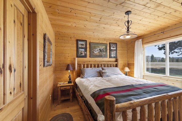 bedroom featuring wooden walls, light wood finished floors, and wood ceiling