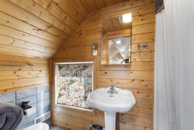 bathroom featuring wooden ceiling, toilet, wooden walls, and lofted ceiling
