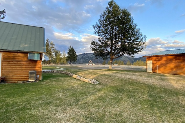 view of yard with central AC and a mountain view