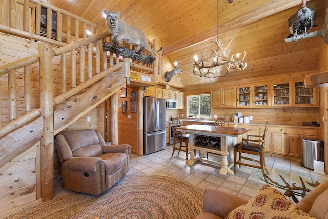 interior space featuring light tile patterned floors, a notable chandelier, wooden ceiling, wooden walls, and high vaulted ceiling