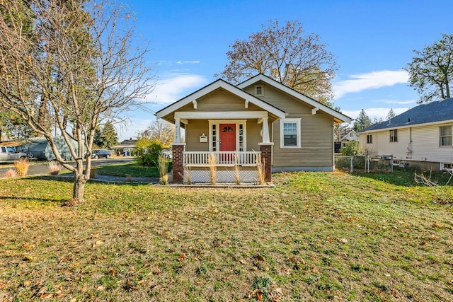bungalow-style home featuring fence, a porch, and a front lawn