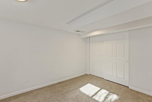 unfurnished bedroom with visible vents, light colored carpet, and baseboards