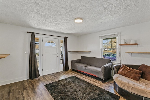 entrance foyer with a textured ceiling, wood finished floors, and baseboards