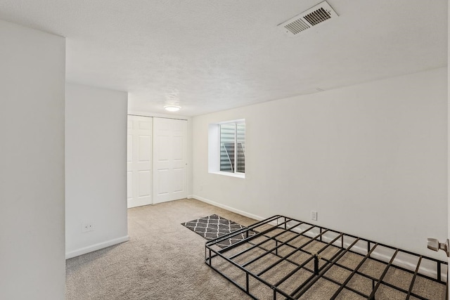 carpeted empty room featuring baseboards and visible vents