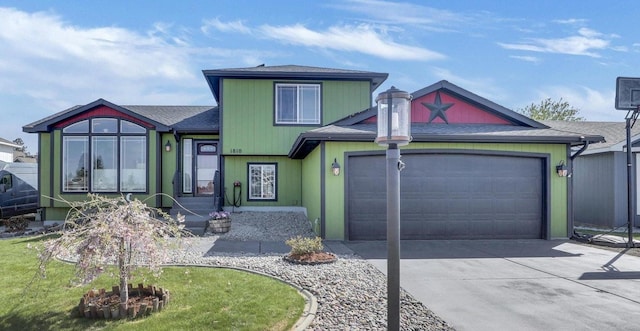 tri-level home featuring driveway, a garage, and roof with shingles