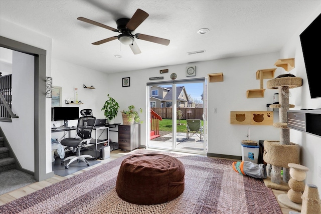 office area featuring baseboards, visible vents, a ceiling fan, and light wood-style floors
