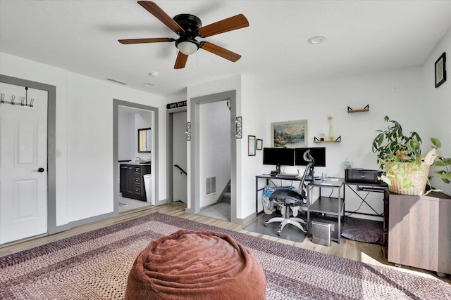 office area featuring visible vents, a ceiling fan, light wood-style flooring, and baseboards