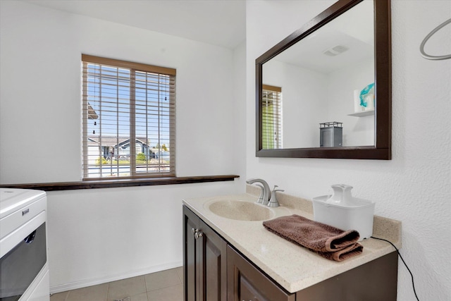 bathroom with tile patterned flooring, a wealth of natural light, and vanity