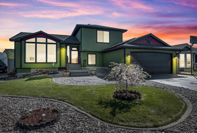 view of front of house featuring a garage, concrete driveway, and a yard