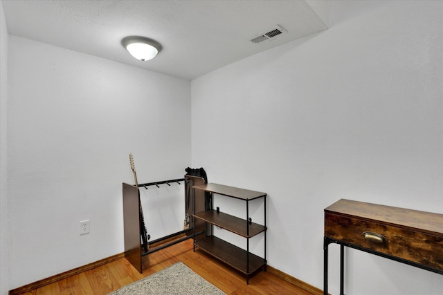 interior space featuring visible vents, wood finished floors, and baseboards