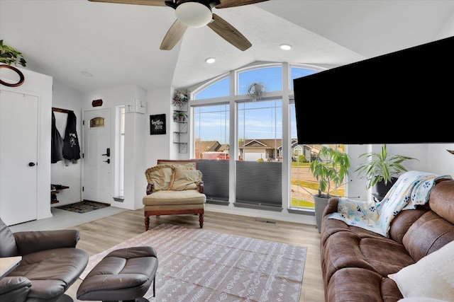 living room with lofted ceiling, wood finished floors, ceiling fan, and visible vents