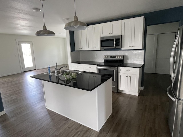 2942 W 18th Ave, Spokane, WA 99224 - kitchen with dark countertops, stainless steel appliances, dark wood-style floors, and a sink