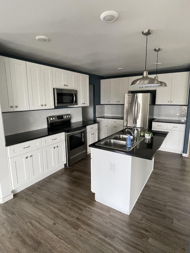 2942 W 18th Ave, Spokane, WA 99224 - kitchen featuring dark wood finished floors, decorative backsplash, appliances with stainless steel finishes, dark countertops, and a sink