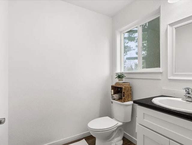 2942 W 18th Ave, Spokane, WA 99224 - half bathroom featuring wood finished floors, toilet, vanity, and baseboards
