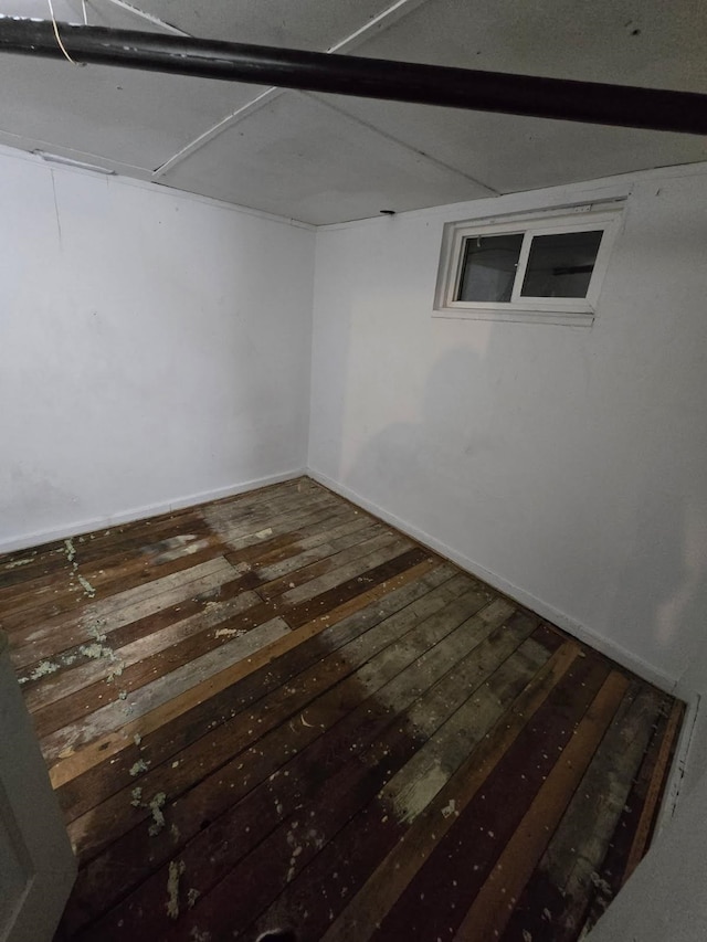 finished basement with baseboards and hardwood / wood-style floors