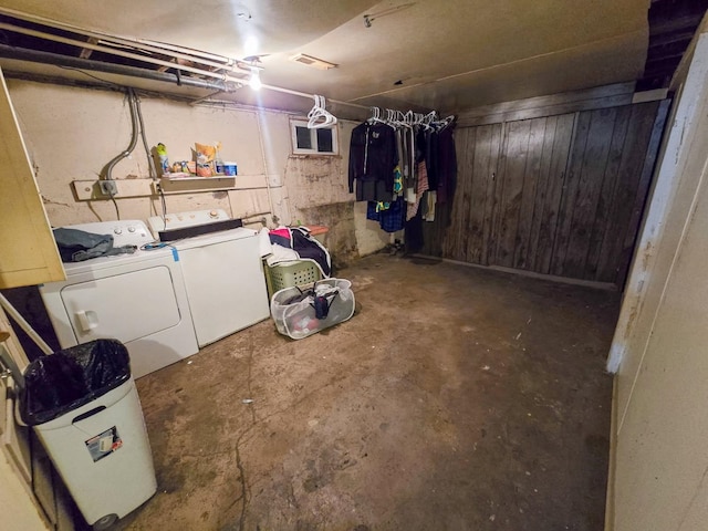 unfinished basement featuring washer and dryer and wooden walls