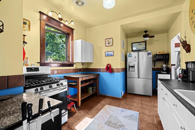kitchen with a ceiling fan, visible vents, dark countertops, white cabinets, and appliances with stainless steel finishes