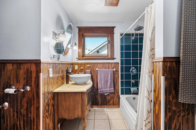 full bath with vanity, tile patterned floors, shower / tub combo, wooden walls, and a wainscoted wall