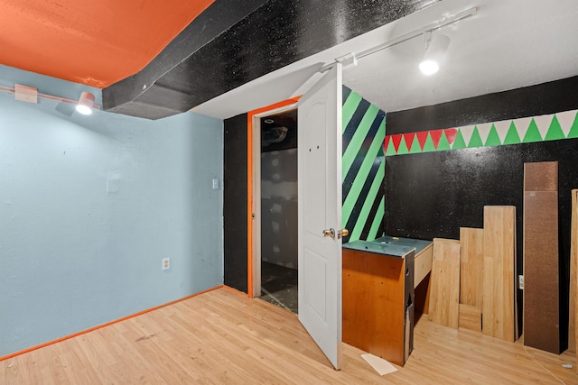 interior space featuring rail lighting and wood finished floors