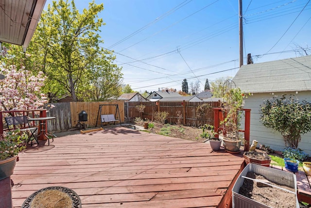 wooden terrace with a fenced backyard