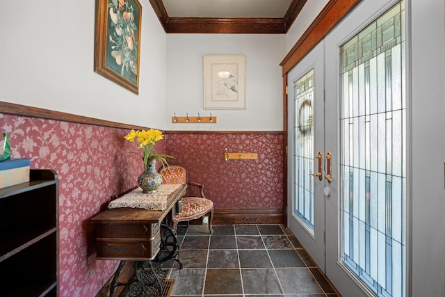 living area featuring crown molding, baseboards, wallpapered walls, and plenty of natural light
