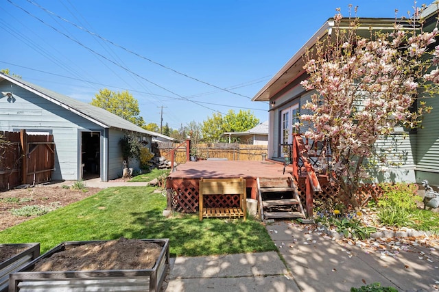 view of yard featuring fence, a vegetable garden, and a wooden deck