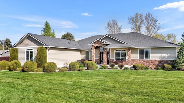 view of front of home featuring a shingled roof, a front lawn, and stone siding