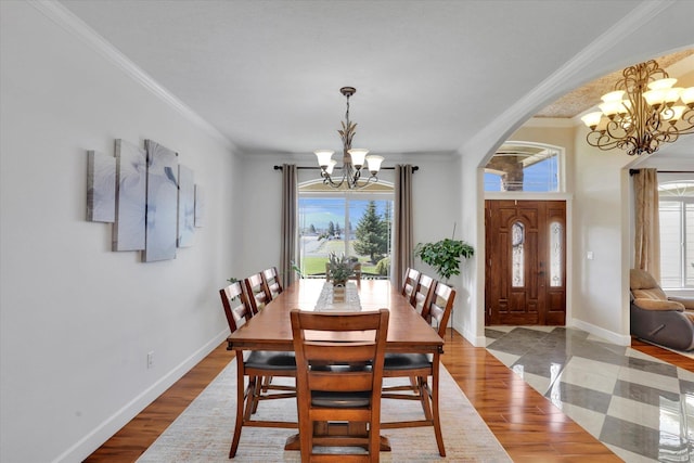 dining area featuring a chandelier, light wood-type flooring, crown molding, and baseboards