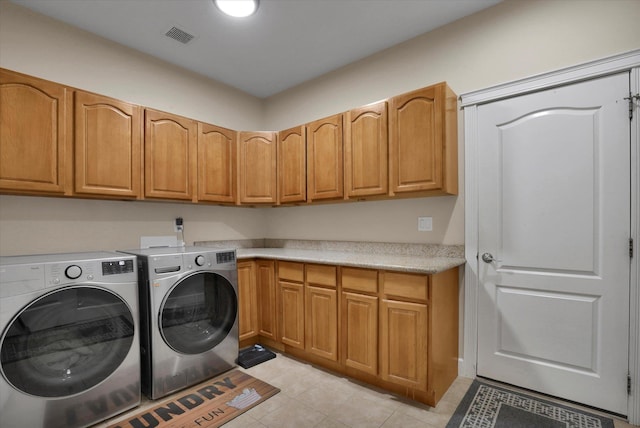 laundry room featuring light tile patterned flooring, visible vents, washer and clothes dryer, and cabinet space