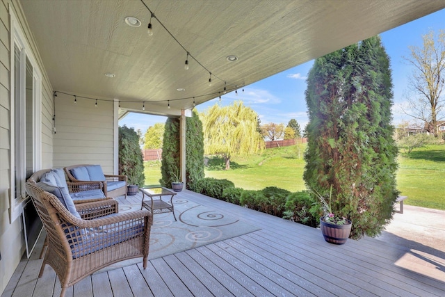 wooden deck with an outdoor hangout area and a yard