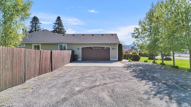 view of front of property with fence, driveway, and an attached garage