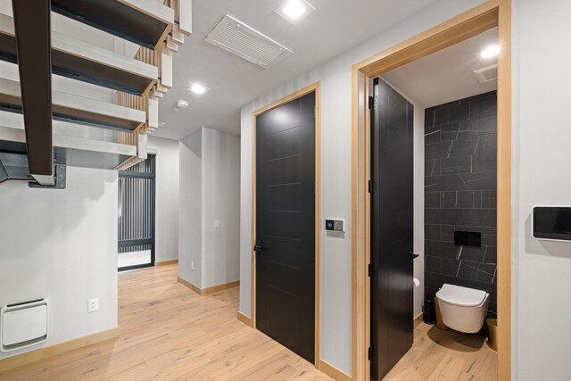 hall featuring visible vents, light wood-type flooring, recessed lighting, and baseboards