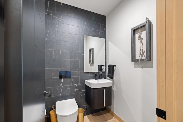 half bath featuring toilet, tile walls, and vanity